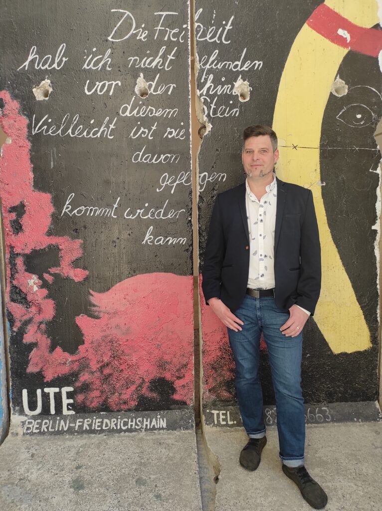 Dirk Loh vor der Berliner Mauer